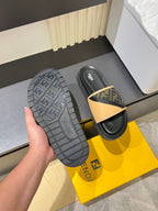 Fendi slide sandals outsole view, textured dark rubber sole with tan FF logo strap