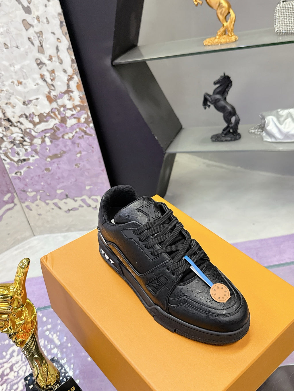 Black lace-up sneaker with embossed upper texture and logo patch on side