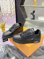 Black low-top sneakers with lace-up closure, textured leather look, and logo stripe