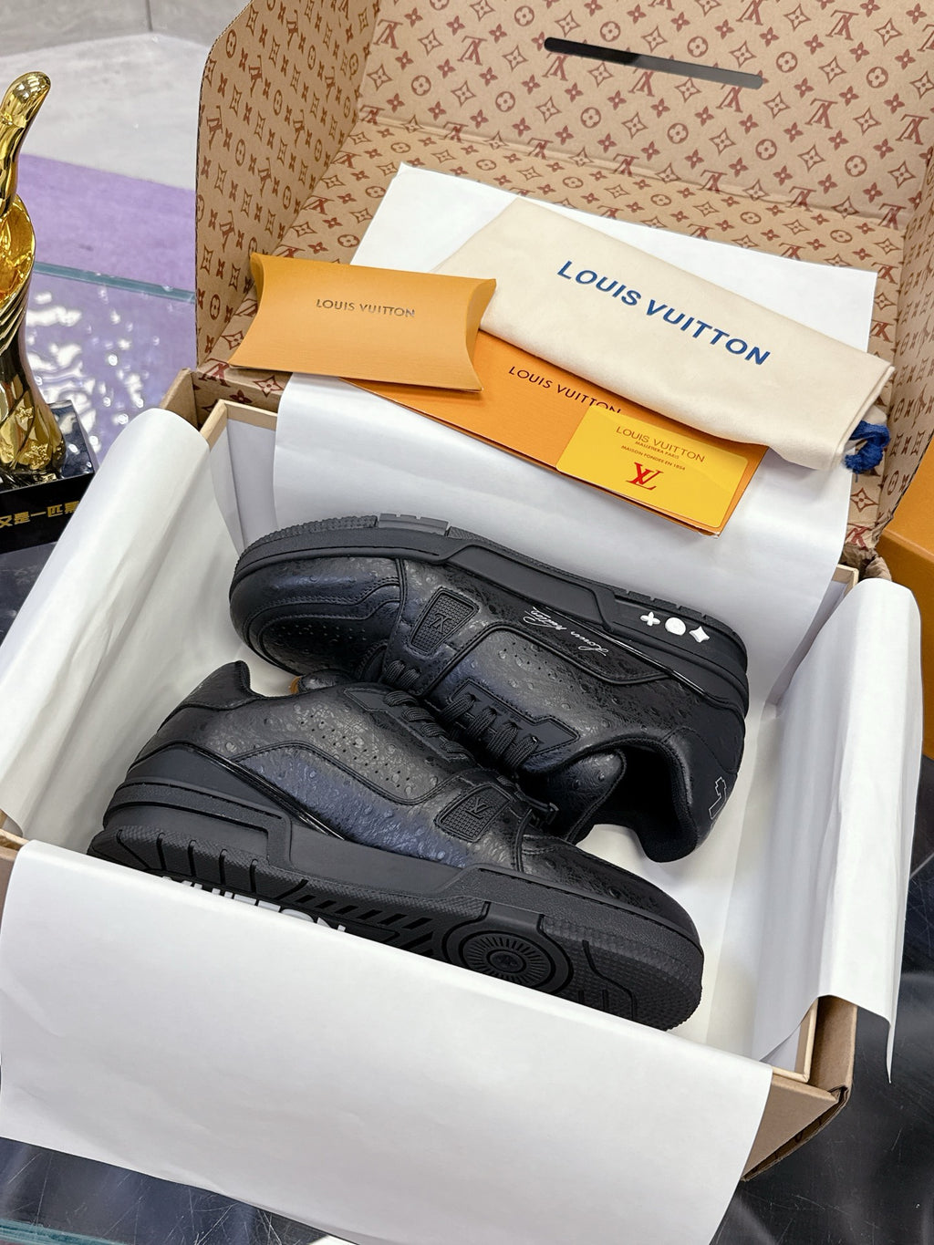 Black low-top sneakers with textured panels, lace-up front, and rubber sole detail