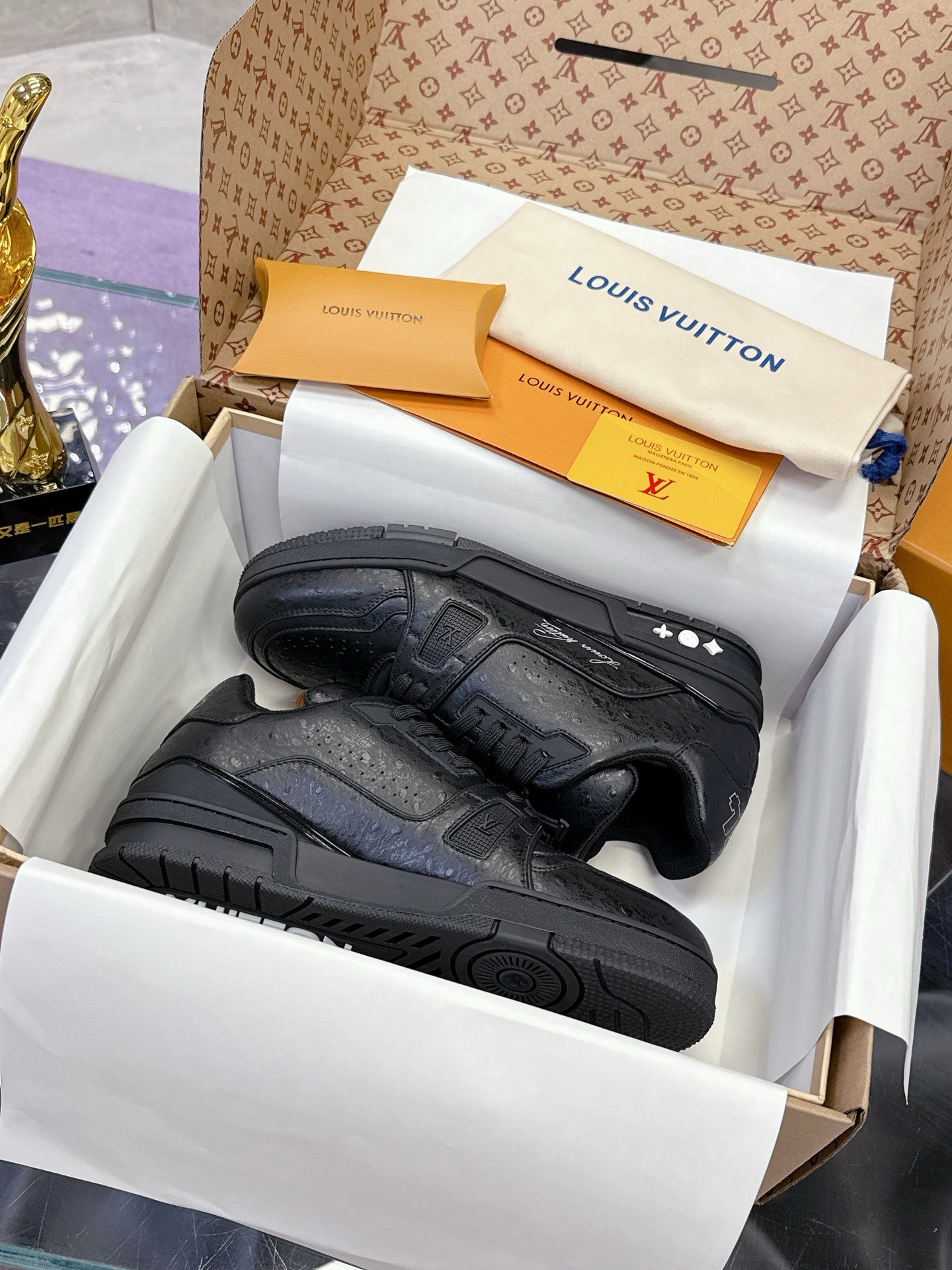 Black low-top sneakers with textured panels, lace-up front, and rubber sole detail