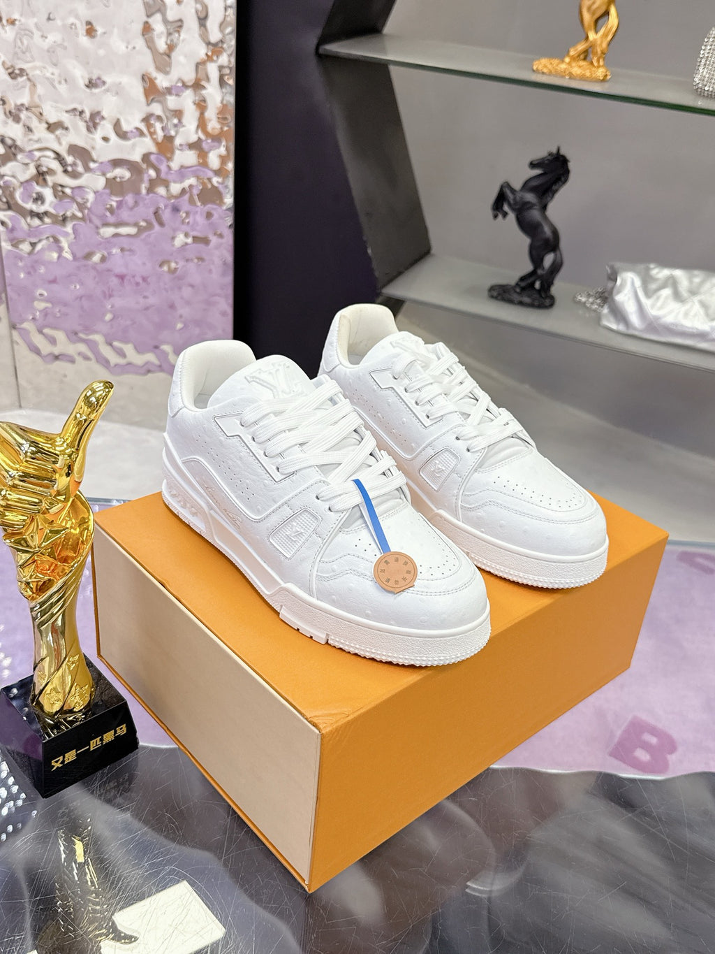 Louis Vuitton white lace-up sneakers on a box, blue side stripe, tan logo patch