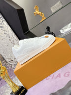 Louis Vuitton white low-top sneakers showing heel, embossed details, thick rubber sole