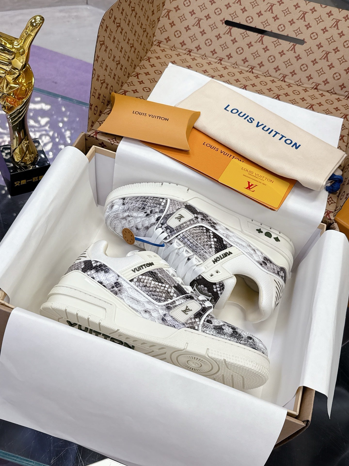 White Louis Vuitton ladies sneakers with patterned side panels and white laces