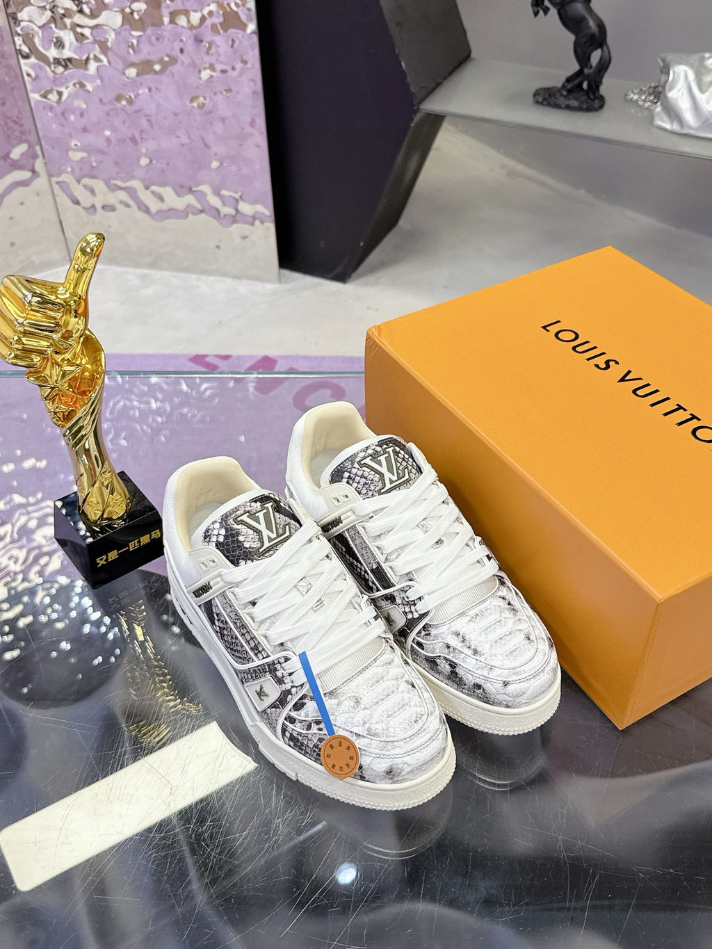 White Louis Vuitton lace-up sneakers with black logo panel and patterned toe cap