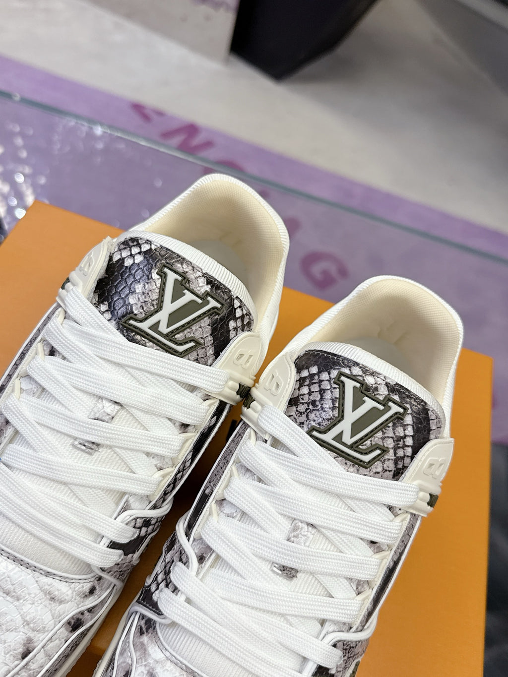 Close-up of white Louis Vuitton sneakers with black monogram logo on the side