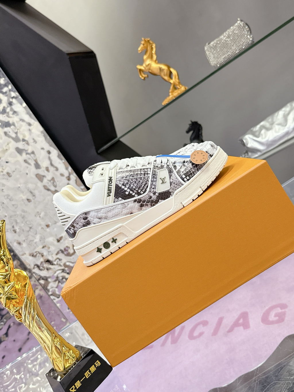 White Louis Vuitton sneakers with black-and-gray patterned panels and lace-up front