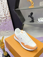White lace-up sneakers with orange quarter panels and stitched emblem on the side
