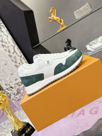 White low-top sneakers with green panels, lace-up front, on orange box