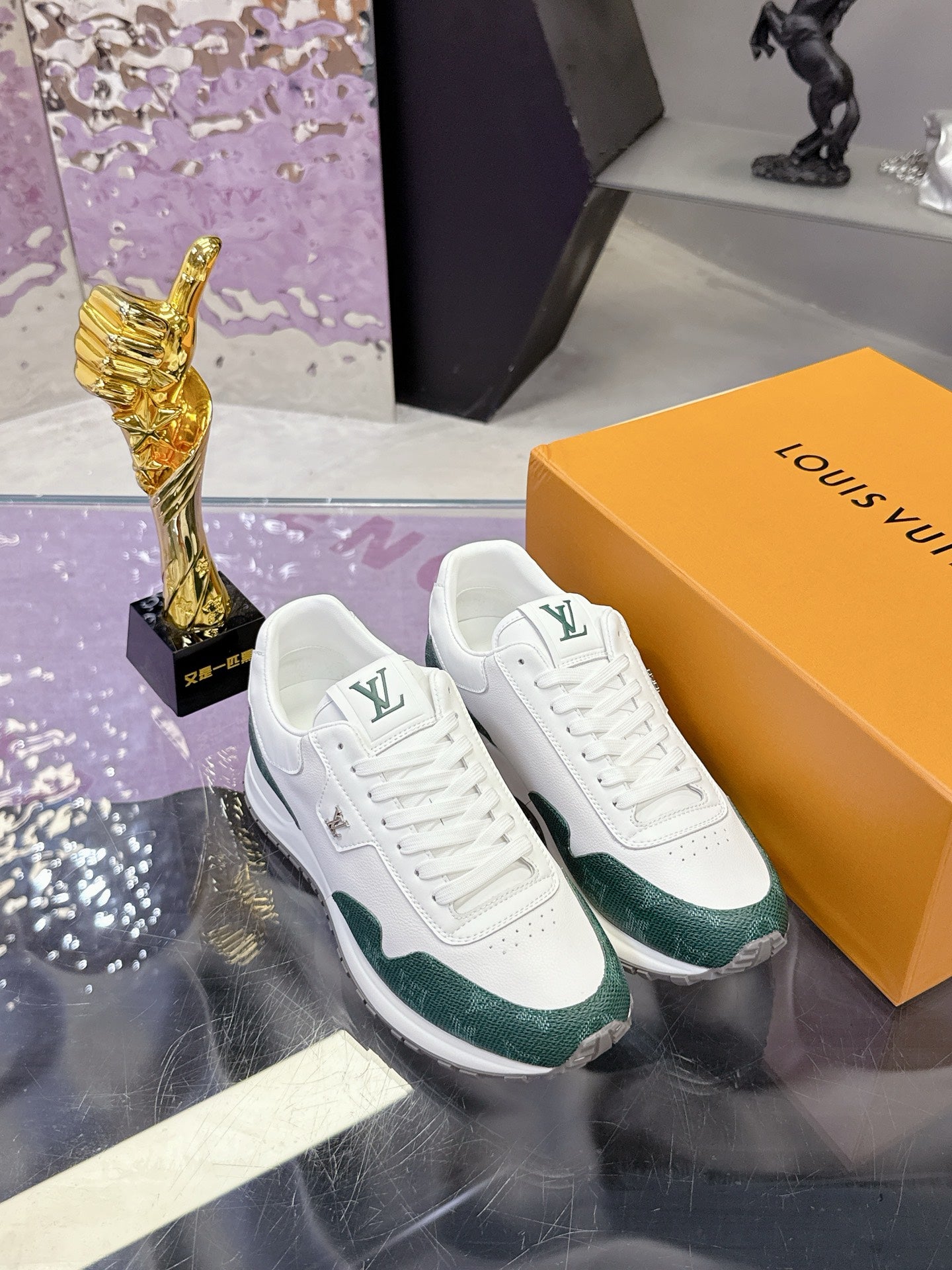 White and green lace-up sneakers with Louis Vuitton logo, on display box