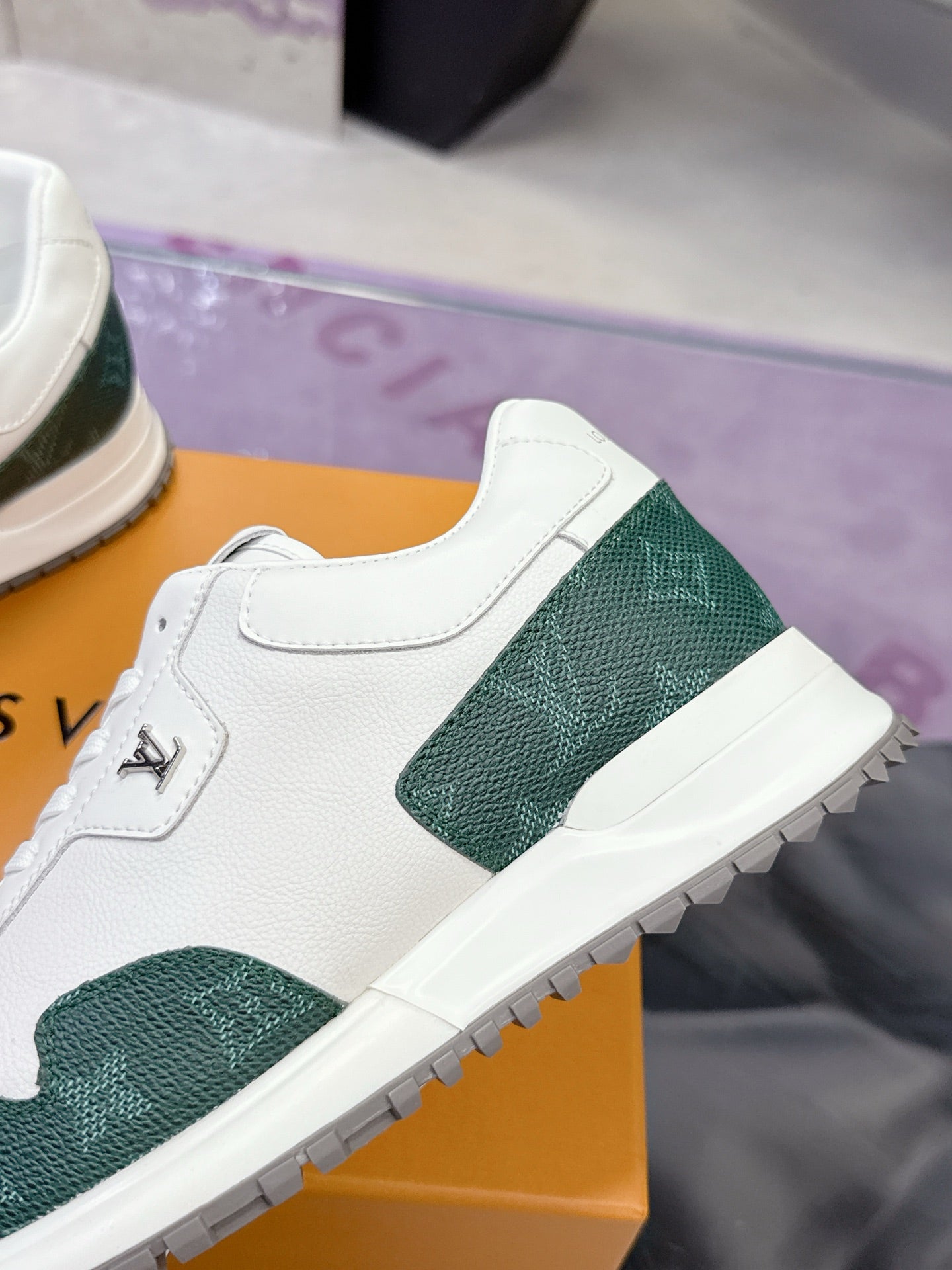 Close-up of white leather sneaker with green textured side panel