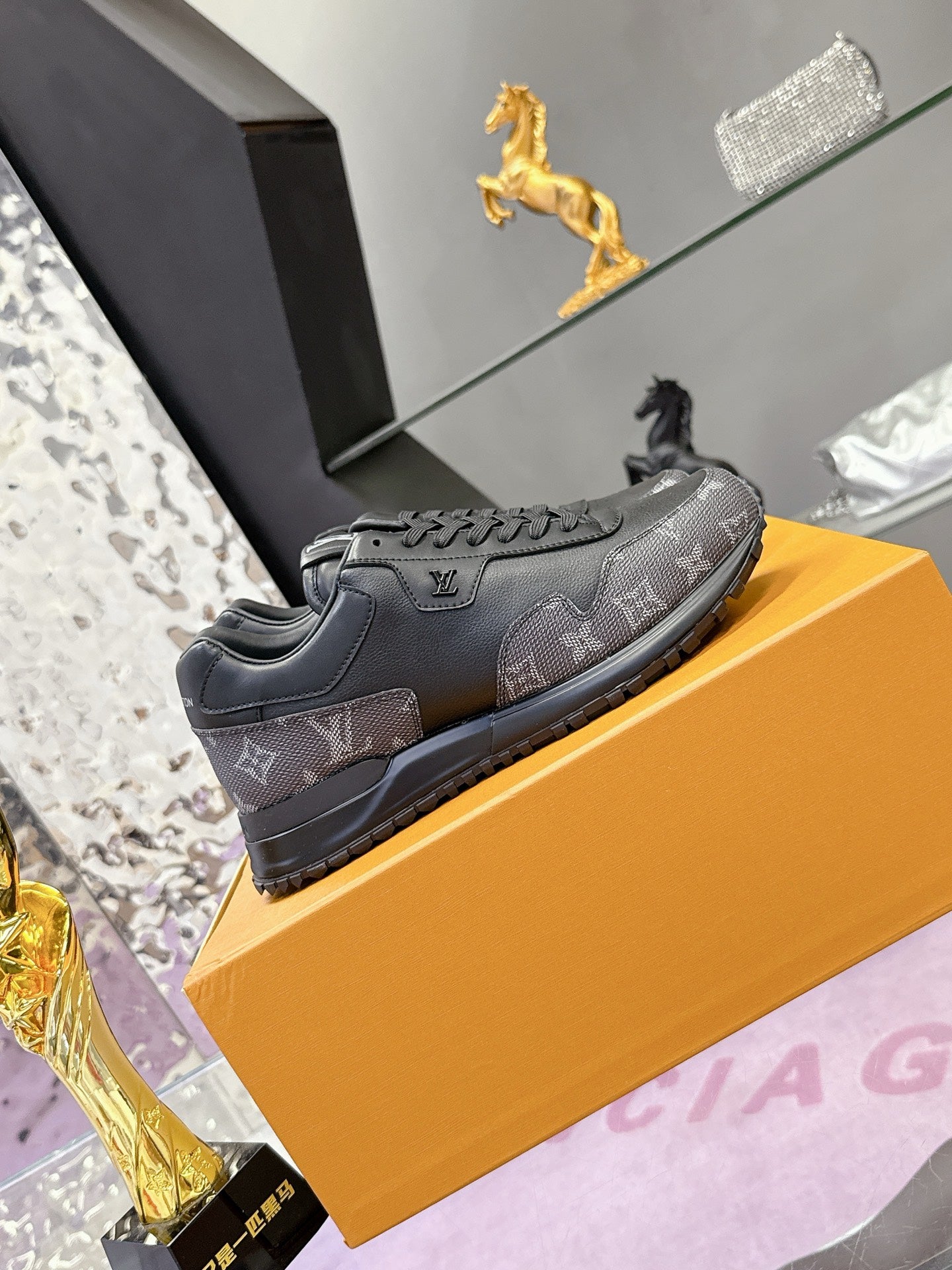 Louis Vuitton low-top sneakers in dark gray/black monogram, side view on box