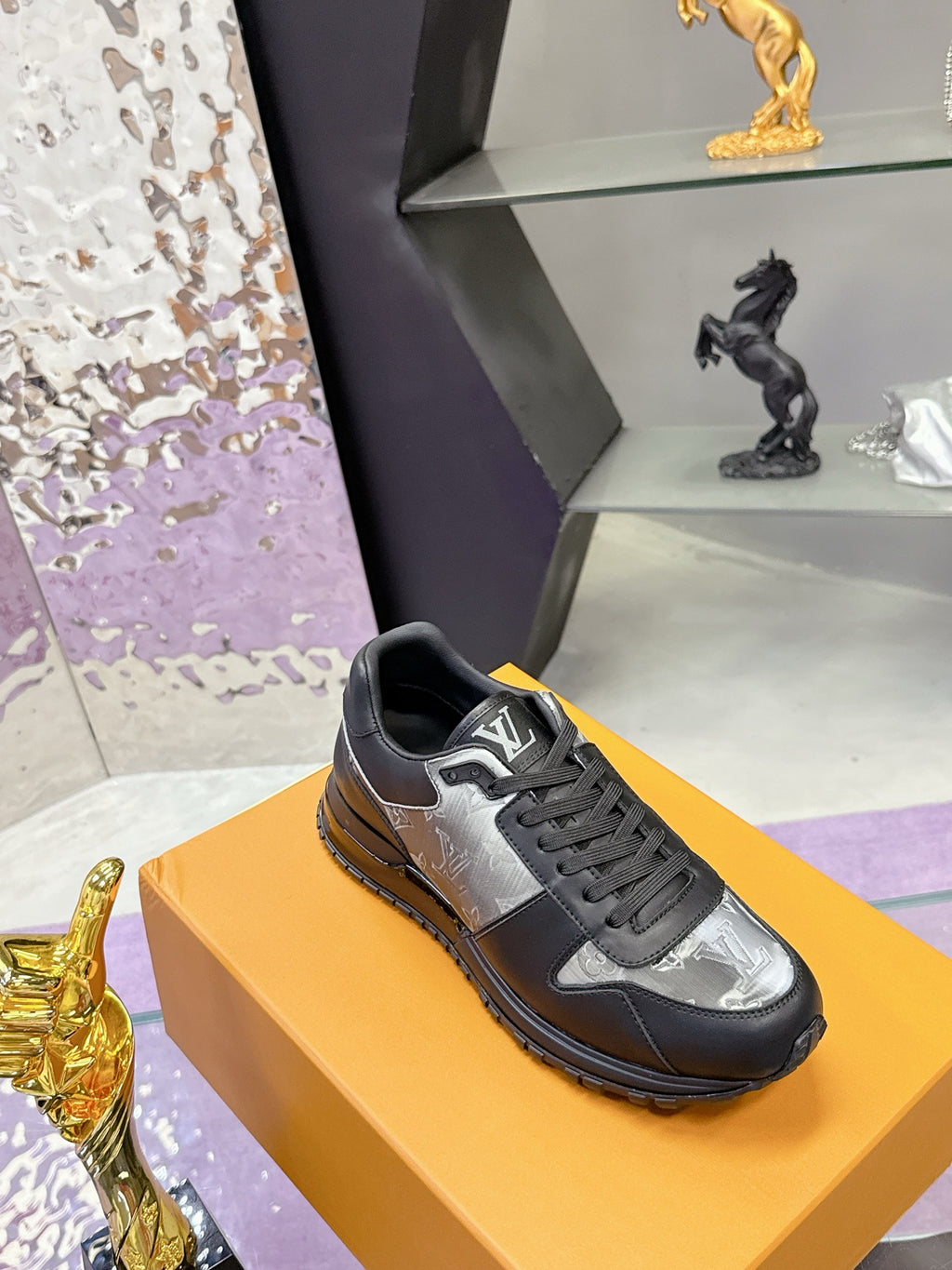 Louis Vuitton lace-up sneakers, dark leather with silver logo panel, low profile sole.
