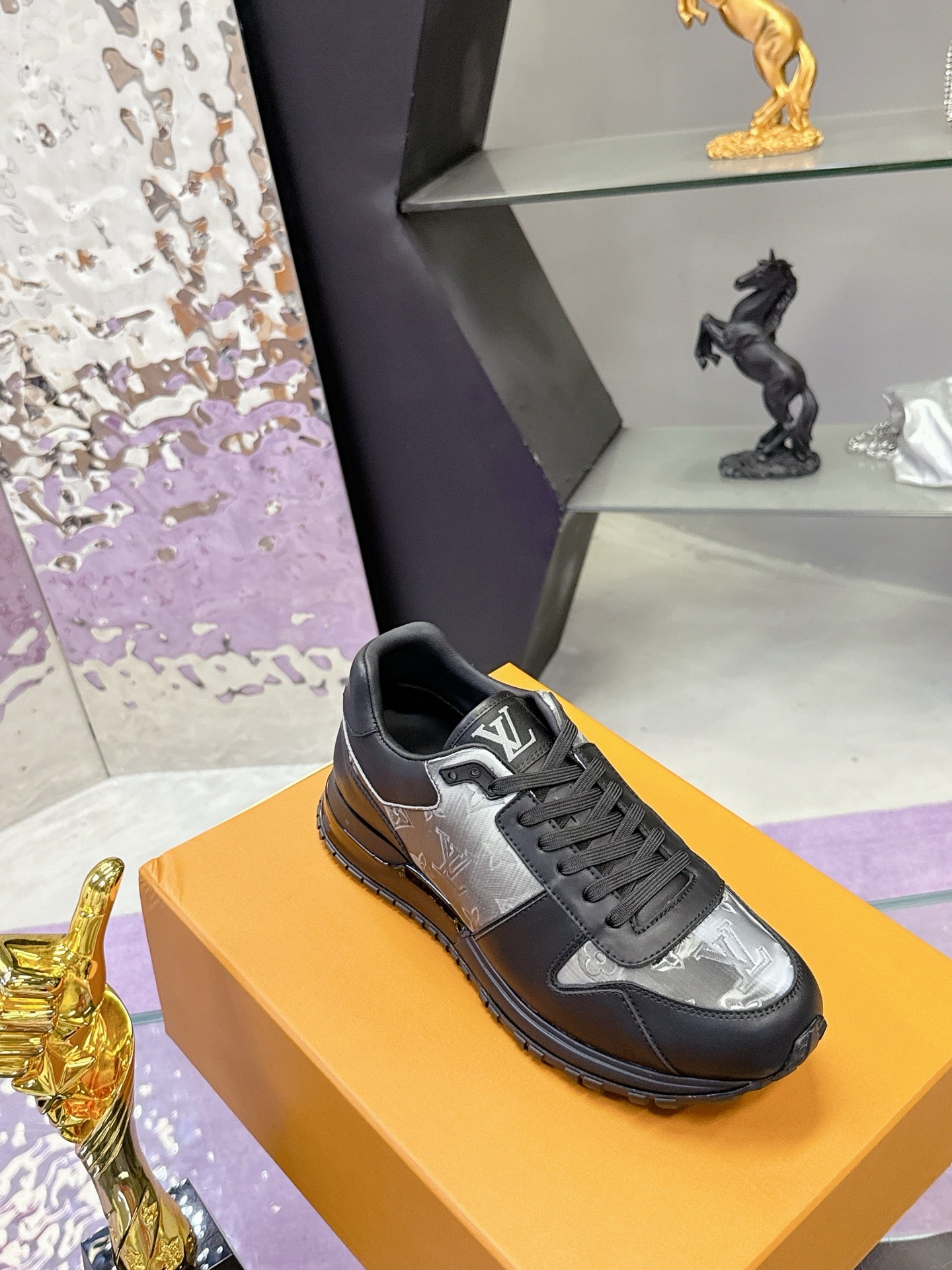 Louis Vuitton lace-up sneakers, dark leather with silver logo panel, low profile sole.