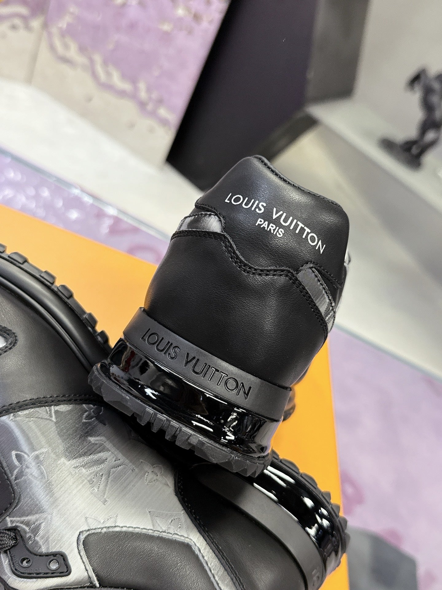 Louis Vuitton sneakers heel view, black leather uppers with Louis Vuitton branding.