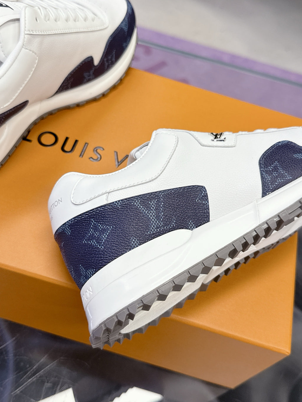 Louis Vuitton ladies sneakers close-up, white leather with navy monogram heel and sole