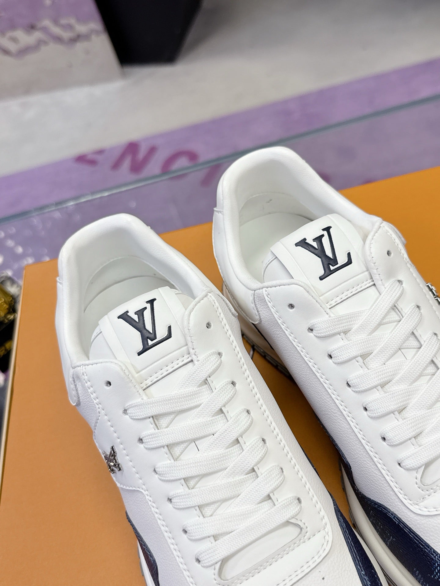 Louis Vuitton ladies sneakers front view, white leather with navy logo patch and laces