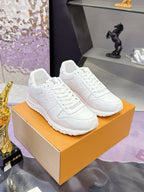 Pair of white women's lace-up sneakers with monogram detail and cushioned rubber sole
