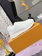 White women's lace-up sneaker with embossed monogram side and raised tread sole