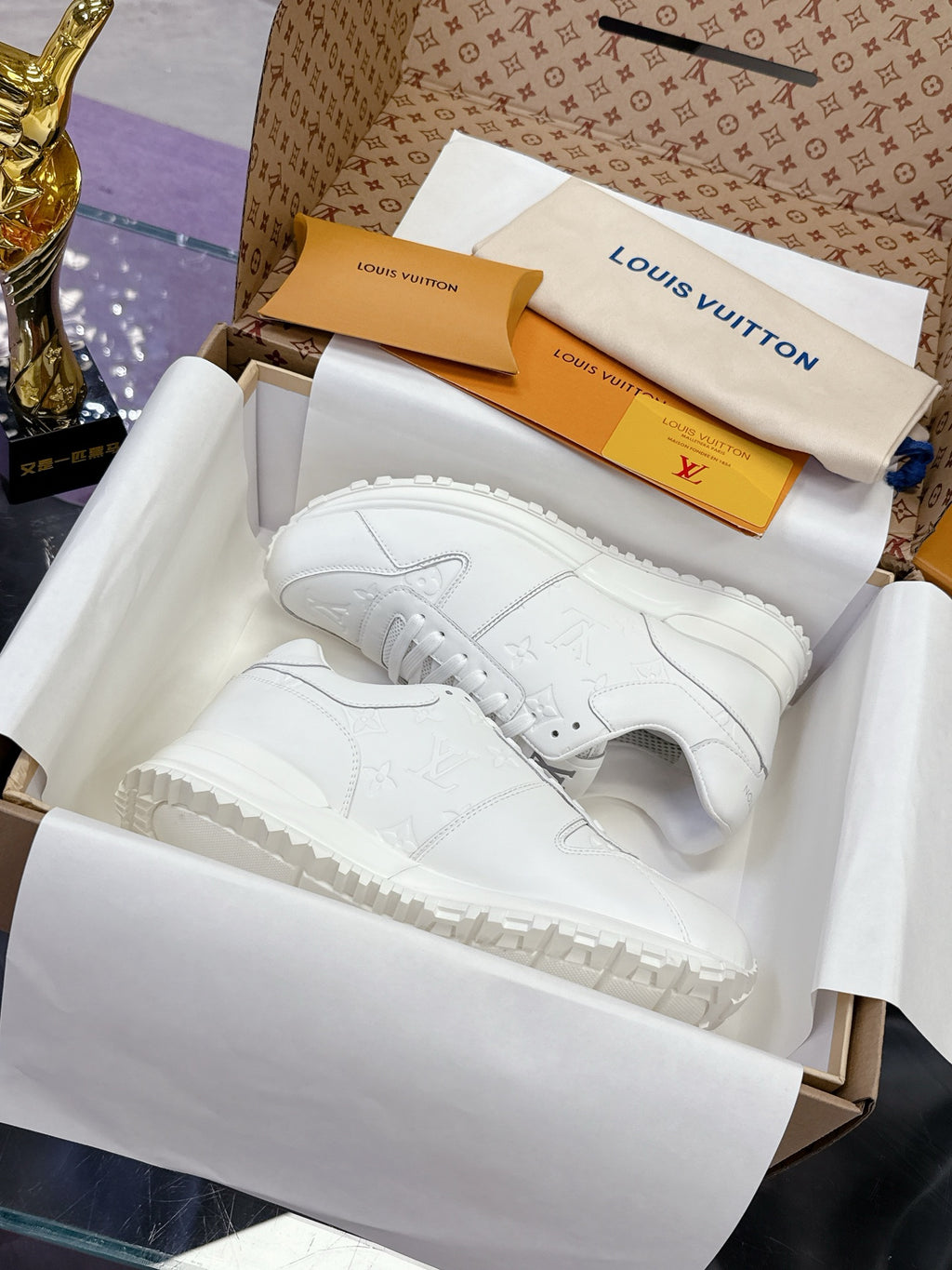 White women's lace-up sneakers with monogram-style embossed pattern and thick sole