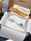White women's lace-up sneakers with monogram-style embossed pattern and thick sole