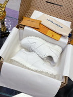 White women's lace-up sneakers with monogram-style embossed pattern and thick sole