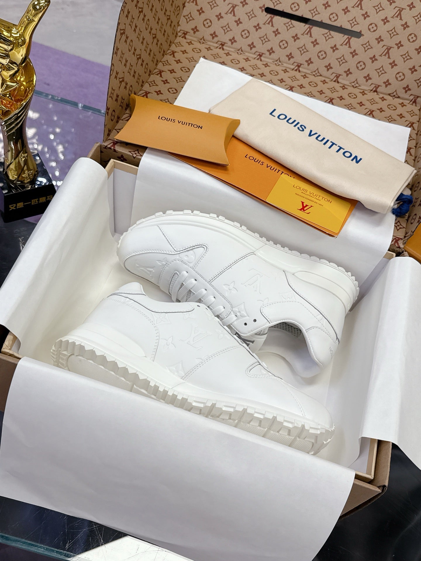 White women's lace-up sneakers with monogram-style embossed pattern and thick sole
