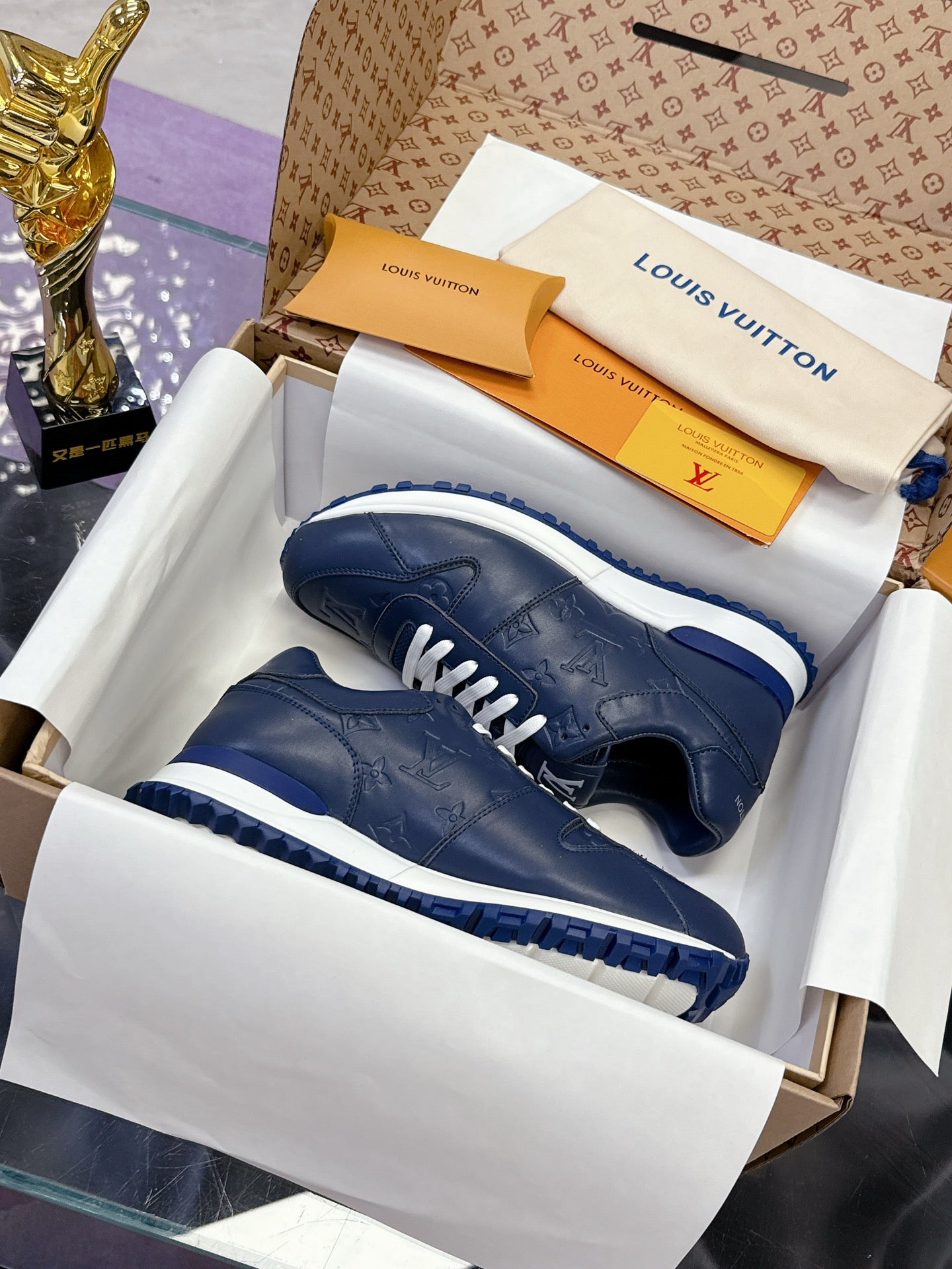 Blue leather low-top sneakers in box, white laces and chunky white-blue sole.