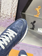 Blue leather low-top sneaker close-up, white laces, embossed logo on toe cap.