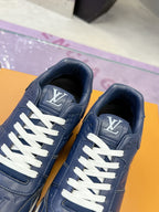 Blue leather sneakers close-up, white laces, LV tongue logo and padded collar.