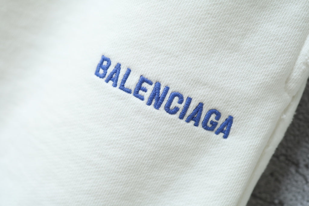 Balenciaga logo on white fabric of the shorts, in blue lettering