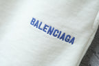 Balenciaga logo on white fabric of the shorts, in blue lettering