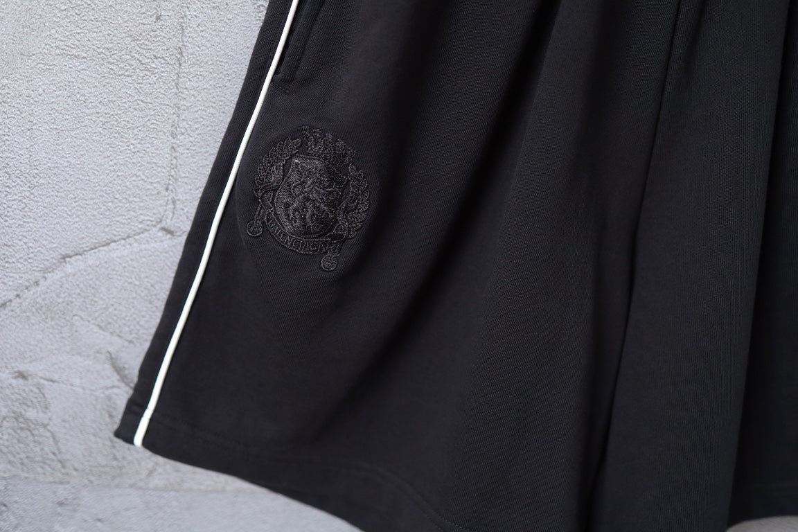 Black shorts front with embossed crest emblem and side stripe