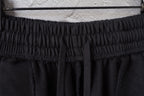 Elastic waistband of black shorts with gathered fabric and drawstring