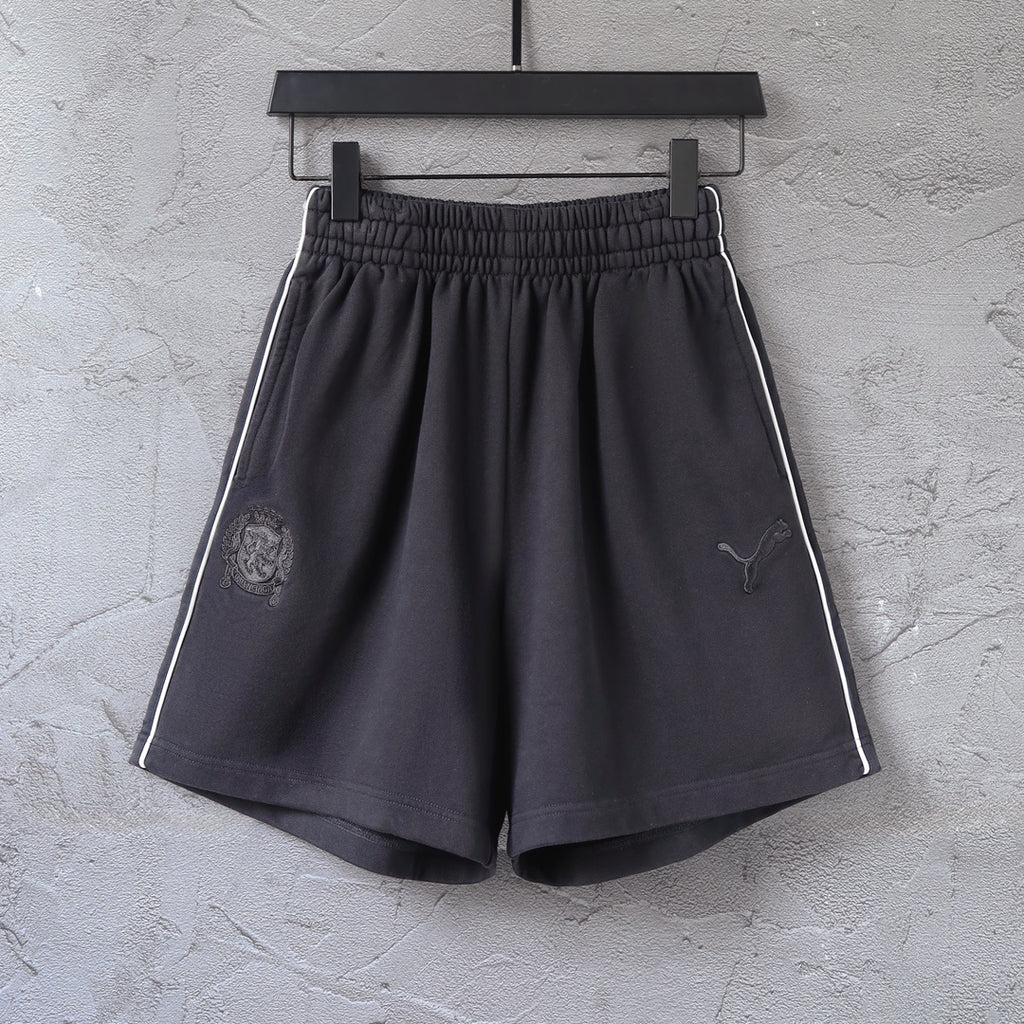 Black shorts with elastic waistband, side stripe, Puma logo and crest patch