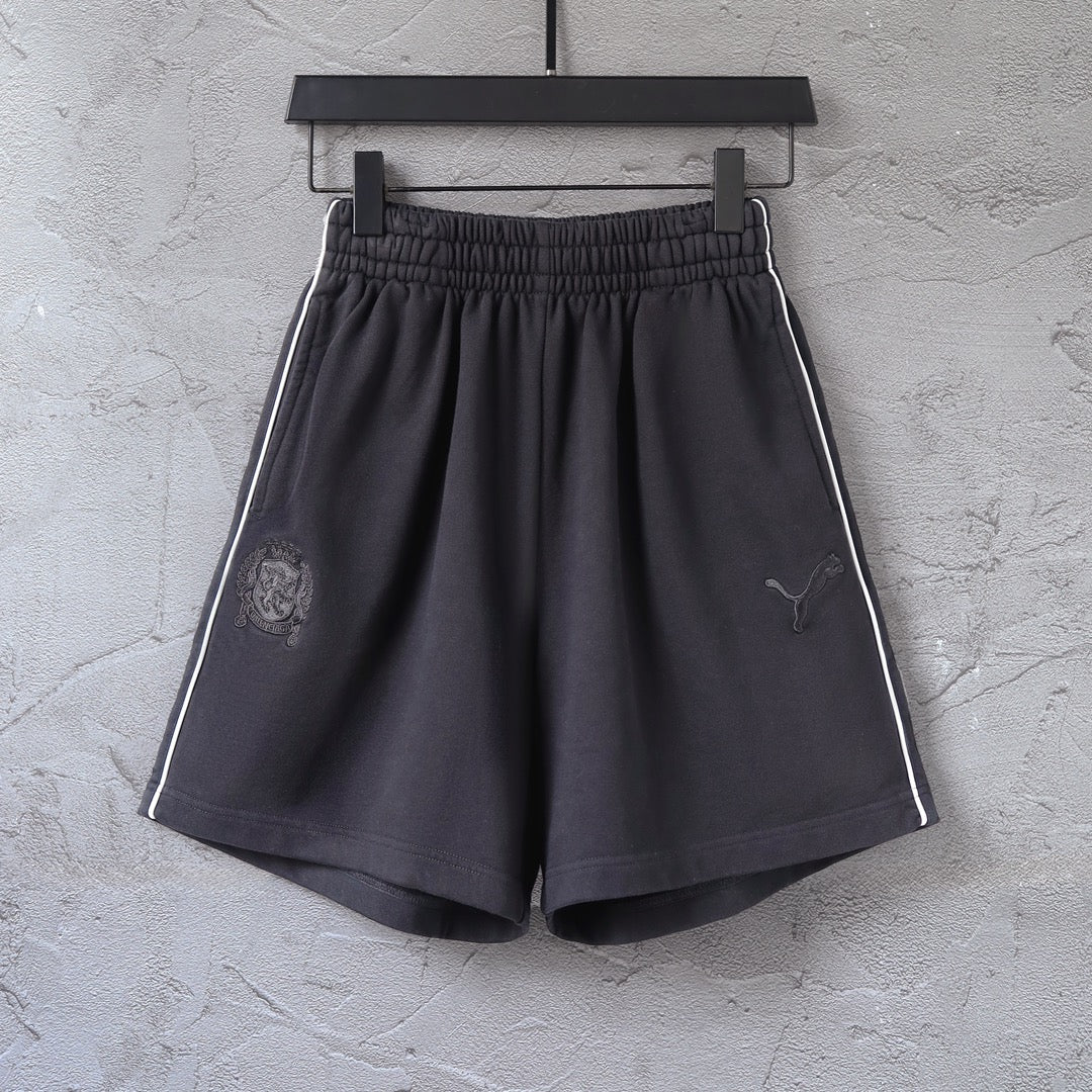 Black shorts with elastic waistband, side stripe, Puma logo and crest patch