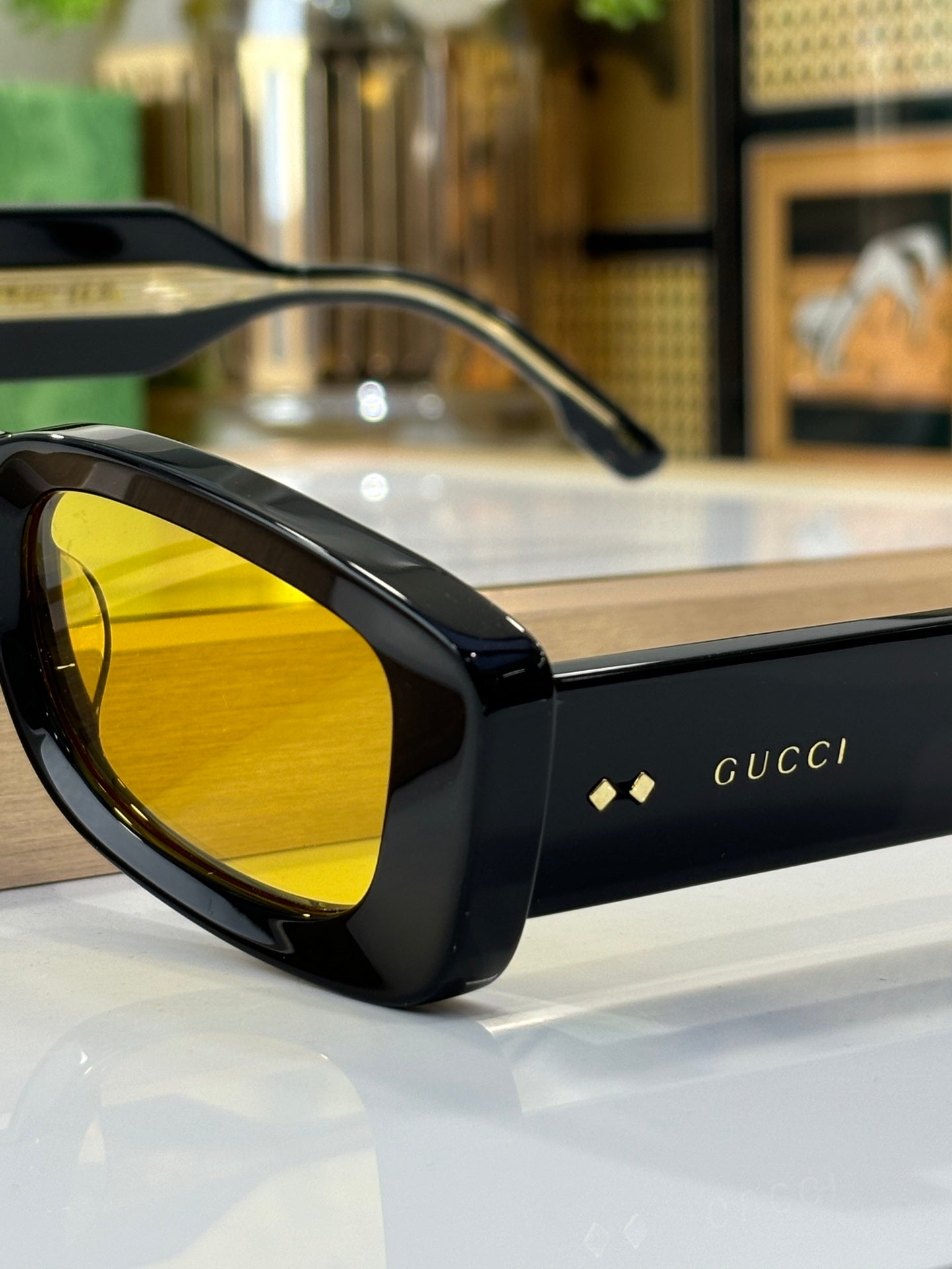 Gucci sunglasses close-up with black frames and yellow tinted lens