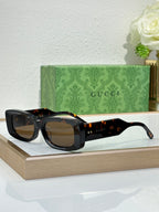 Gucci sunglasses with black frames and amber tinted lenses