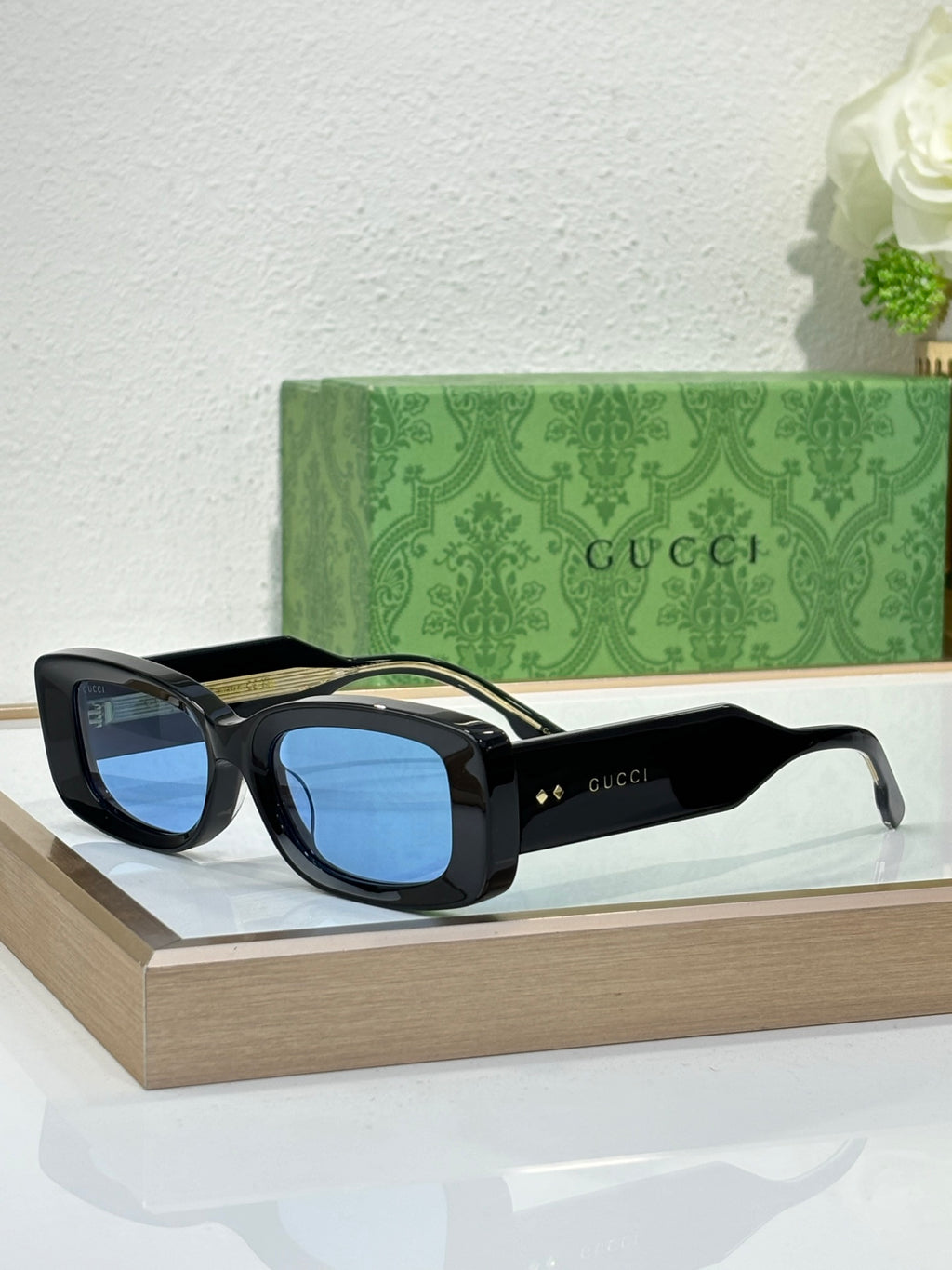 Gucci sunglasses with black frames and blue tinted lenses