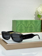 Gucci sunglasses with black frames and dark oval lenses