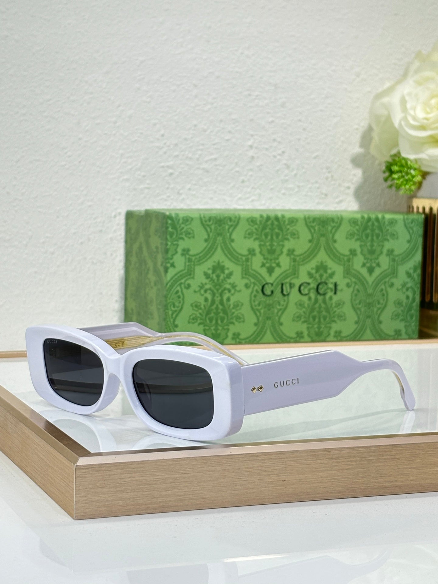 Gucci sunglasses with white frames and dark rectangular lenses
