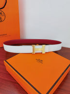 White leather belt with gold-toned square buckle; red reversible side visible