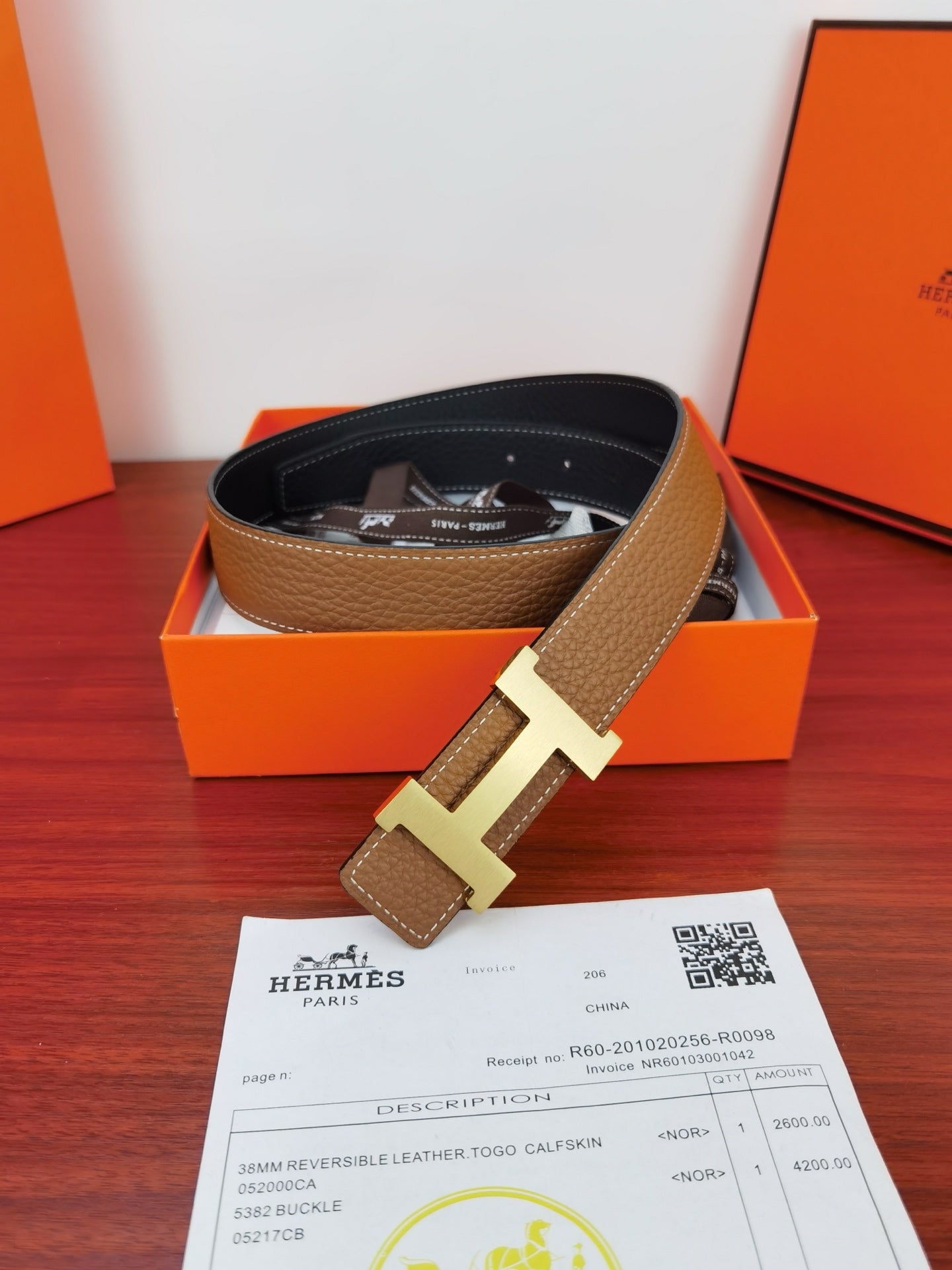 Reversible leather belt in gift box: tan strap with gold H buckle, dark lining visible