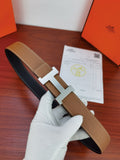 Reversible leather belt with tan strap and gold H buckle, dark underside visible