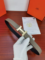 Hermes belt with textured light gray strap and gold-tone H buckle