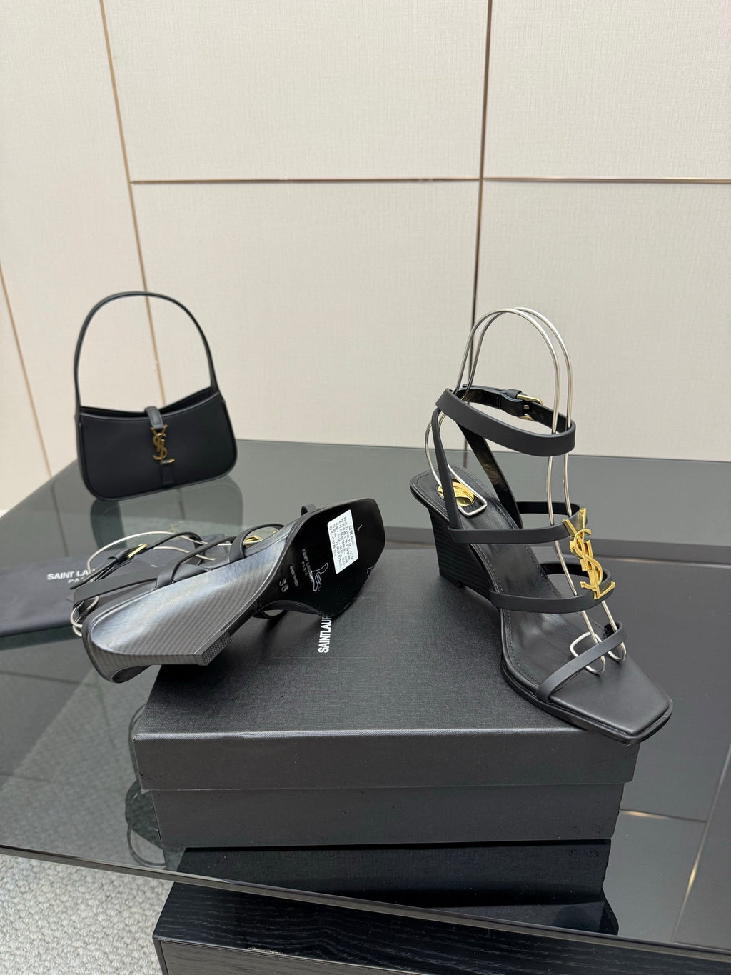 Black heeled sandals and matching black handbag with gold YSL logo
