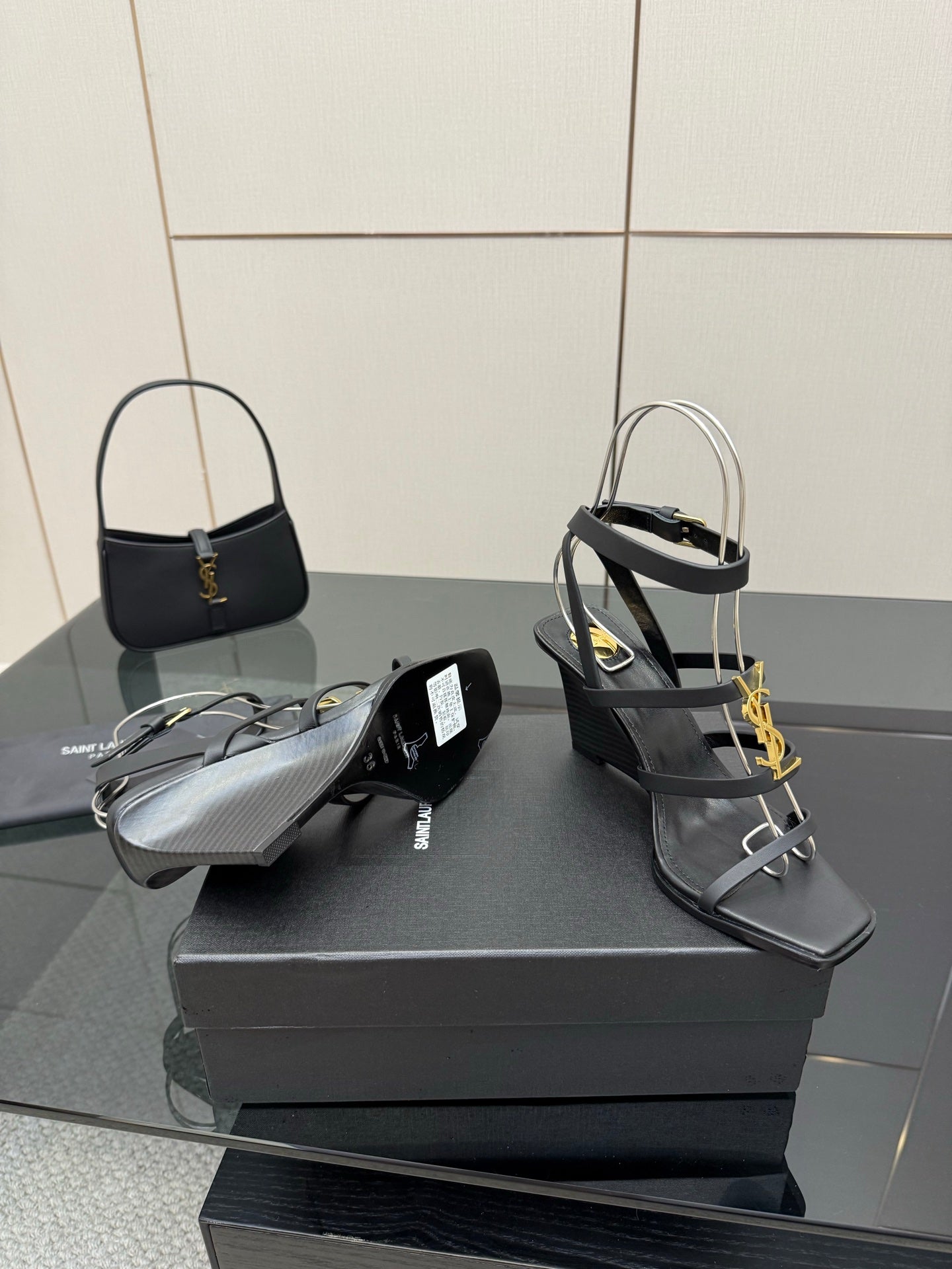 Black heeled sandals and matching black handbag with gold YSL logo