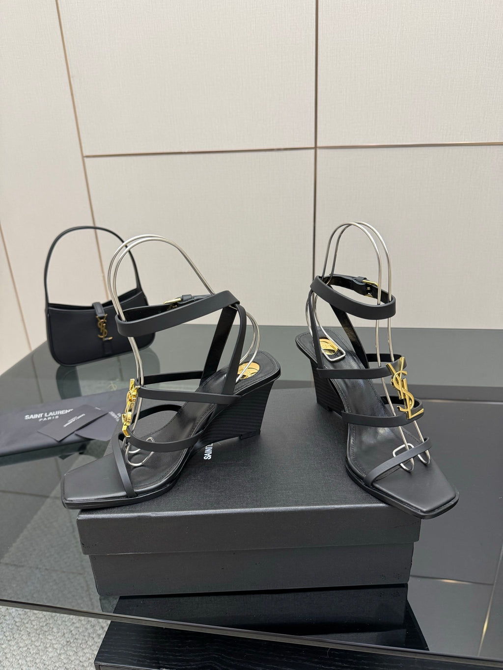 Black heeled sandals with gold chain detail, strappy upper and wedge heel