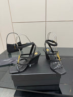 Black heeled sandals with gold chain detail, strappy upper and wedge heel
