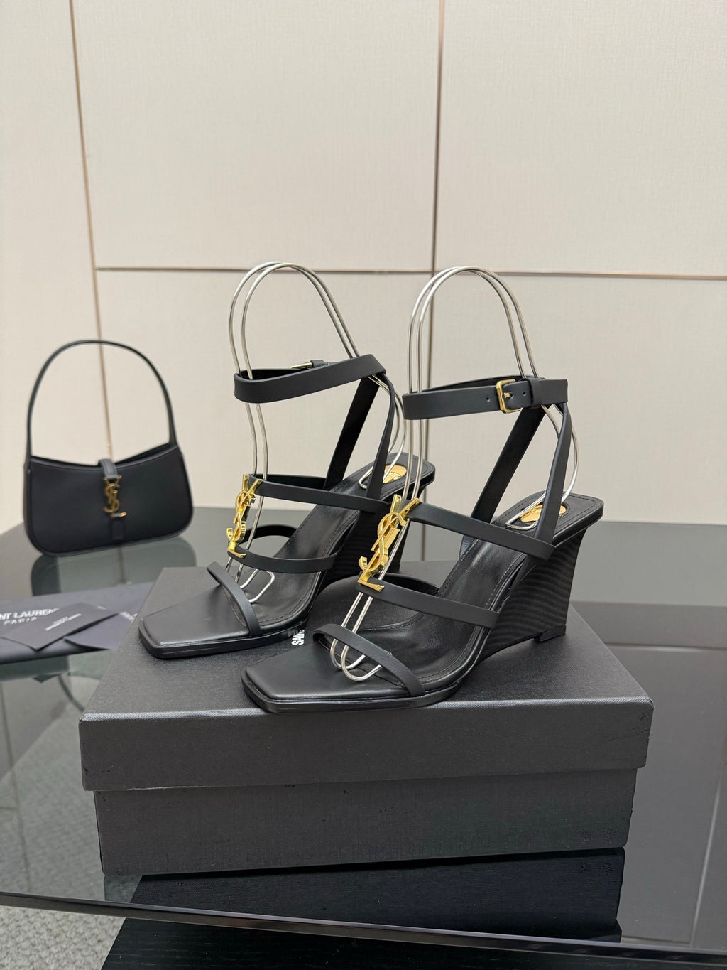 Black heeled sandals with gold chain detail and ankle-strap hardware